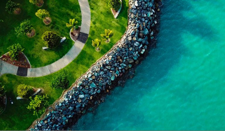 Aerial view of Airlie Beach coastline with lush greenery and turquoise water, Whitsundays Queensland Australia