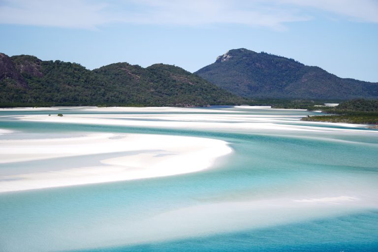 Sweeping aerial view of Whitehaven Beach, Whitsundays, with swirling turquoise water and white silica sand, Queensland Australia