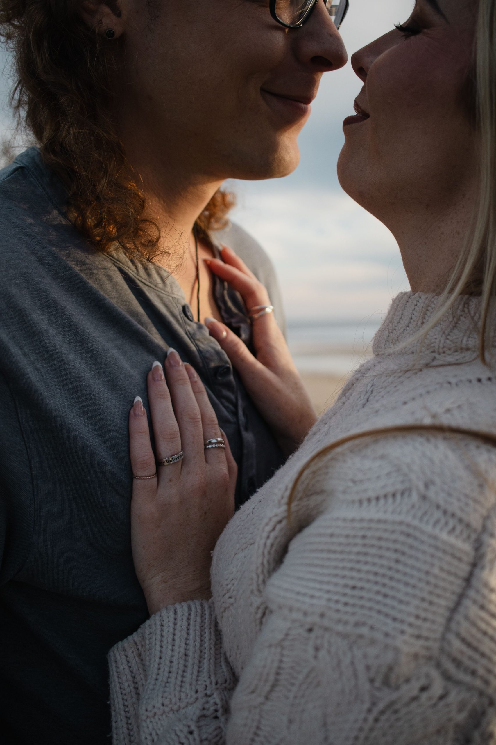 Close-up of a couple embracing in a tender golden-hour moment at sunset on the beach